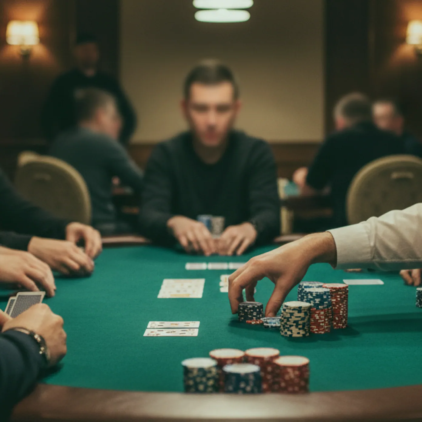 A dealer laying out a hand of five hundred on green felt.