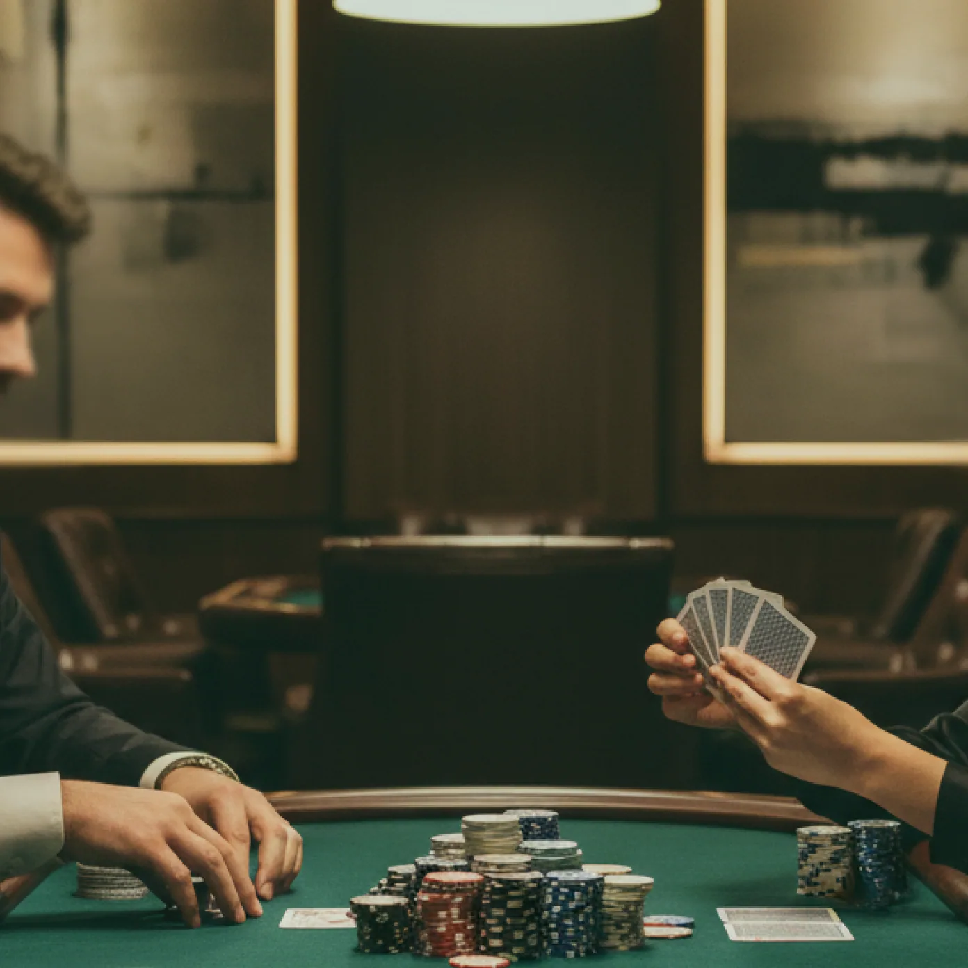 A short stack of hall chips beside a dealer's hand.